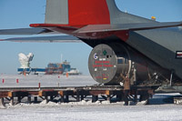 Liquid Helium for use in BICEP2 (in the background to the right), is being unloaded from a LC-130 aircraft at the Geographic South Pole. (<i>Steffen Richter, Harvard University</i>)
